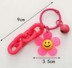 Bild von pinkfarbener Acryl Schlüsselanhänger mit Smiley Sonnenblume und Glöckchen